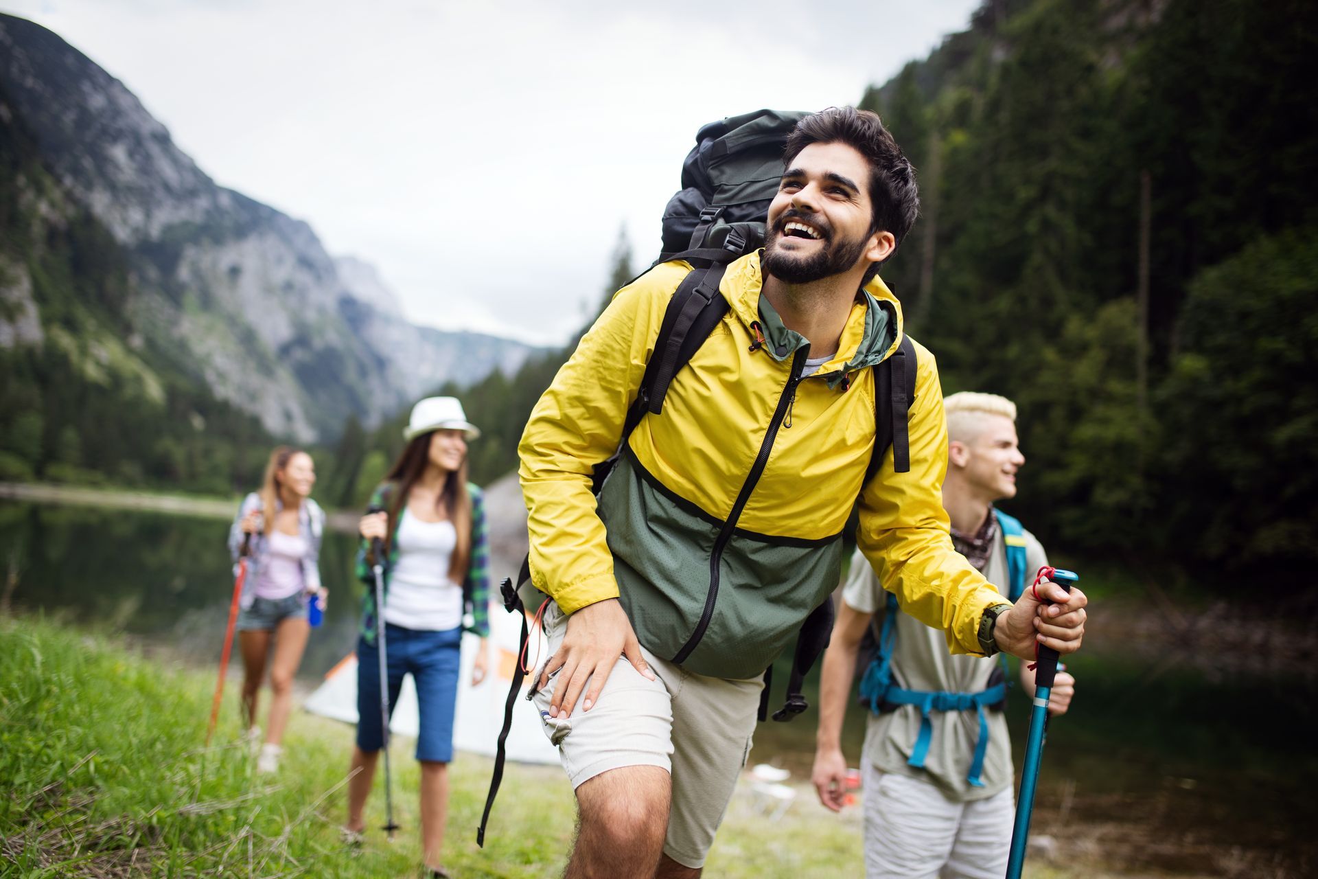 A group of people are hiking in the mountains near a lake.