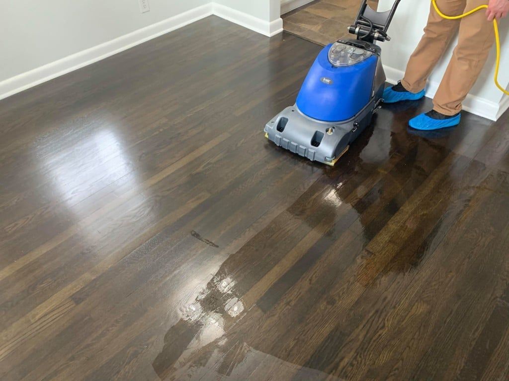 Expert hardwood floor cleaning with a high-powered machine for a polished finish.