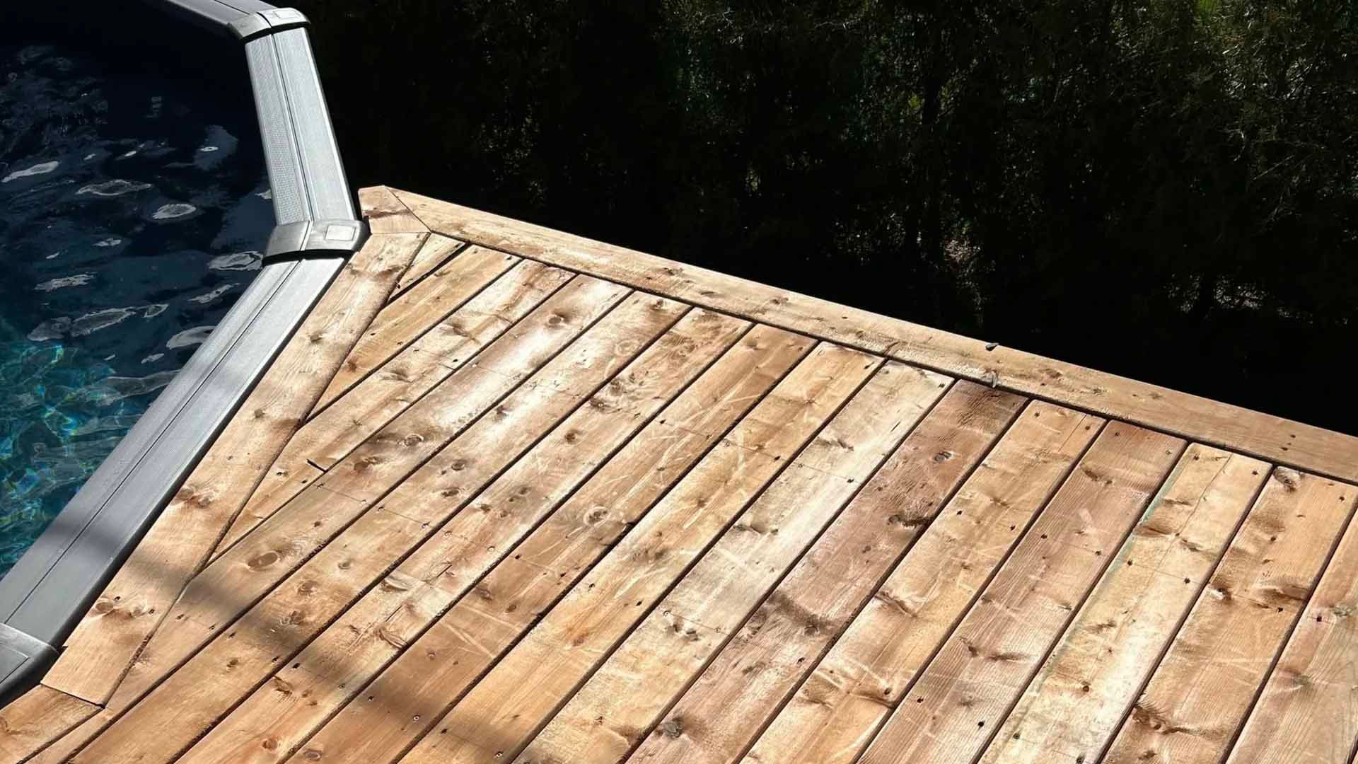 Terrasse en bois au bord de l'eau, avec une gouttière métallique.