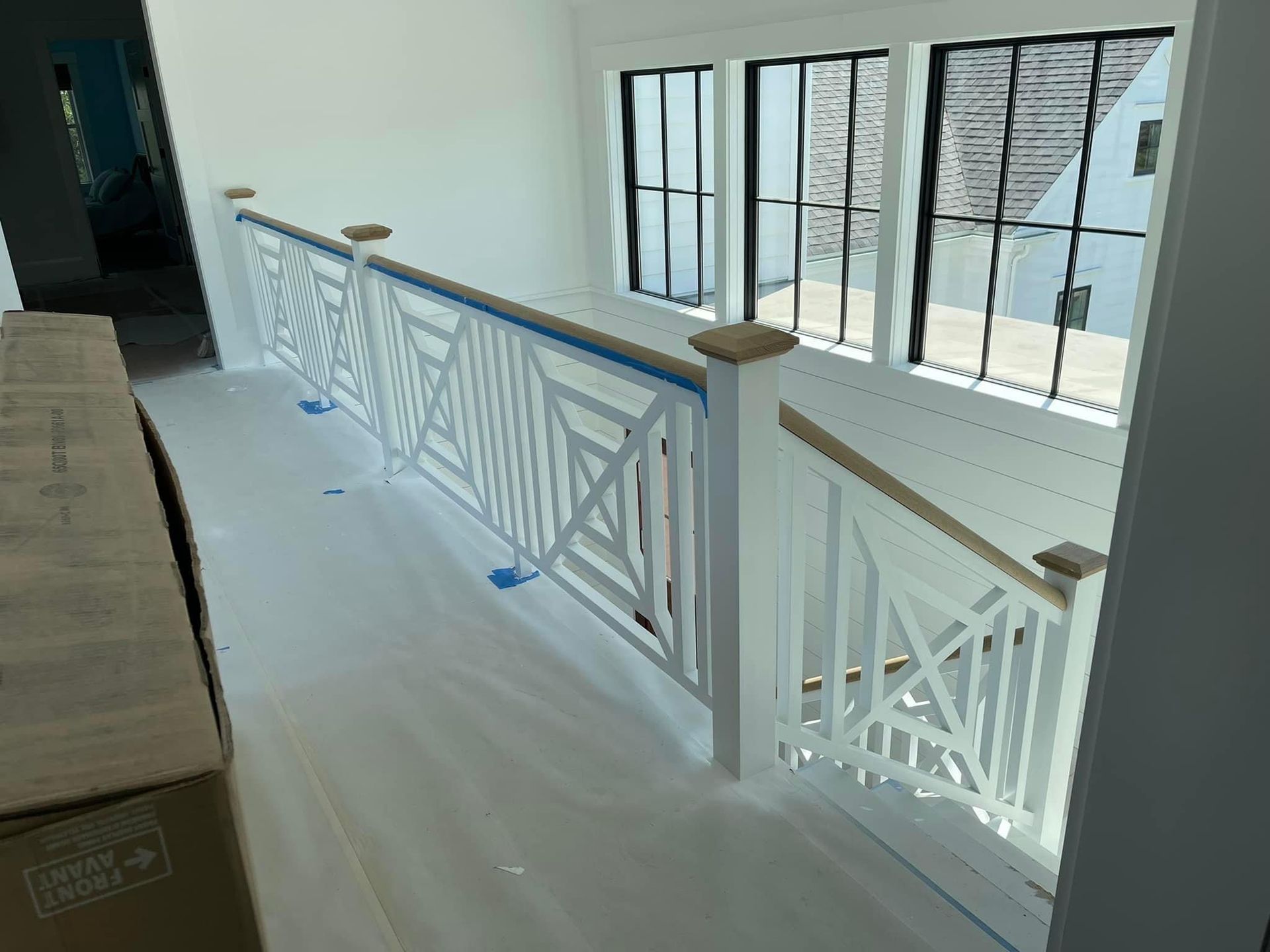 Second-floor overlook view of custom staircase with handcrafted railing, built by A&J Remodel and Construction in a modern Houston home