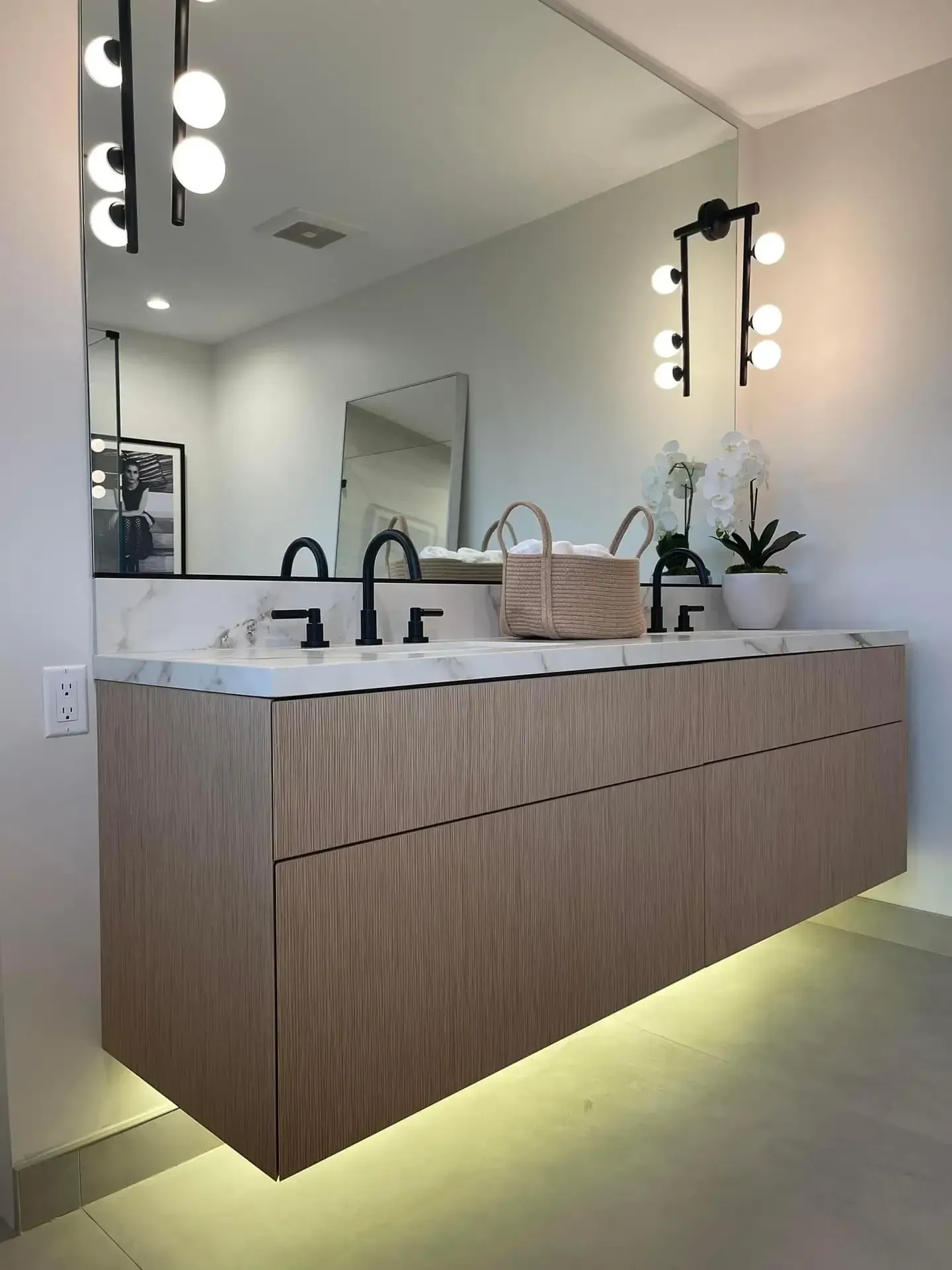 A remodeled bathroom with two sinks and a large mirror perfect lighting