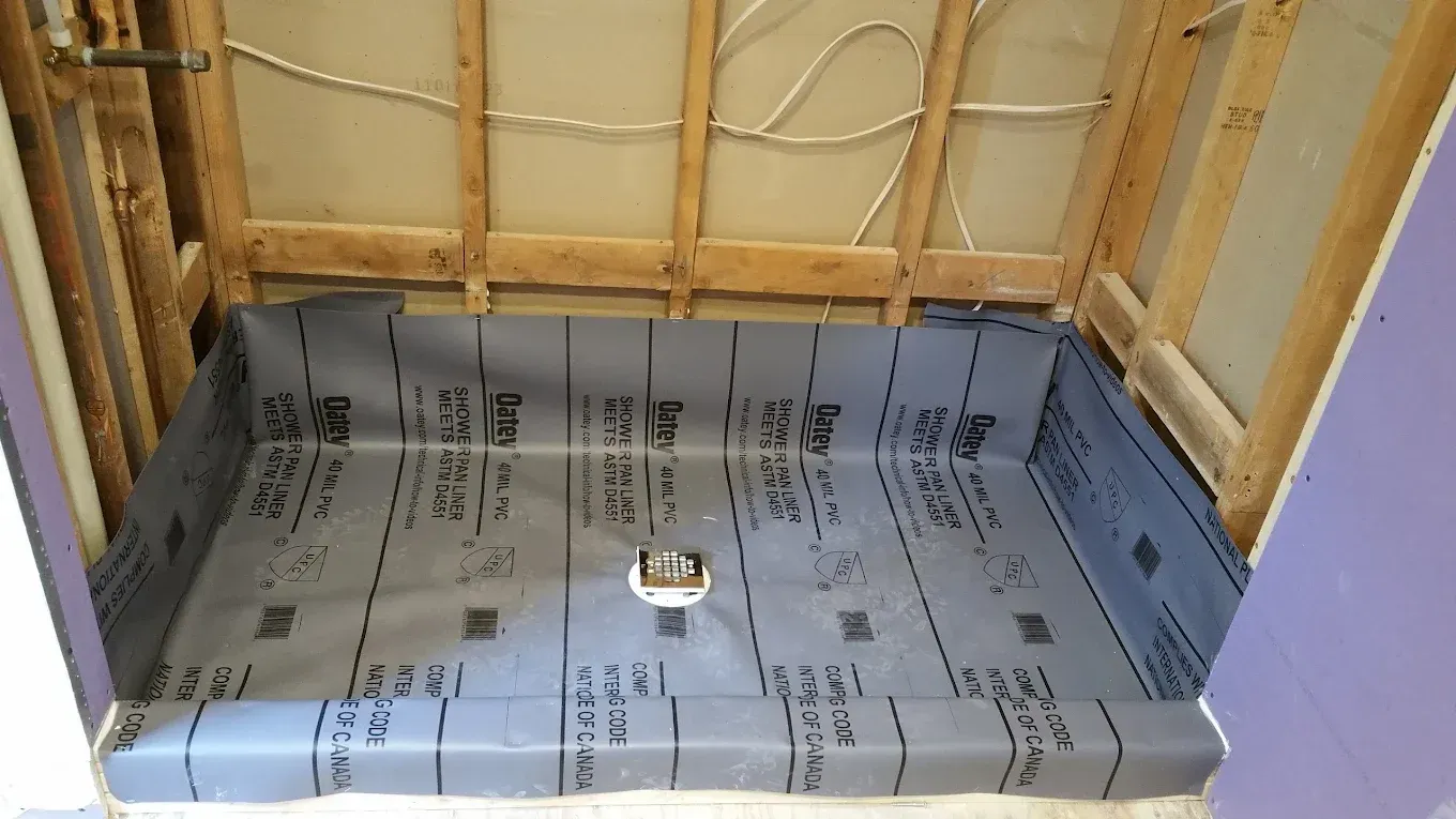 Shower stall under construction, with waterproof membrane lining the floor and walls.