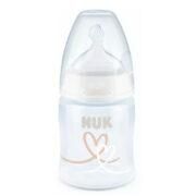 Biberón NUK, de plástico transparente con tetina blanca y diseño en forma de corazón en color marrón.