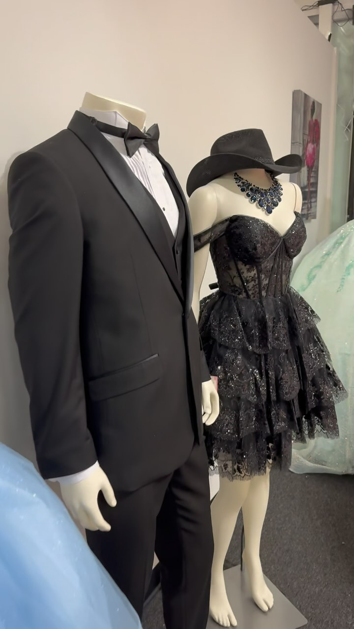 A man in a tuxedo next to a woman in a black dress