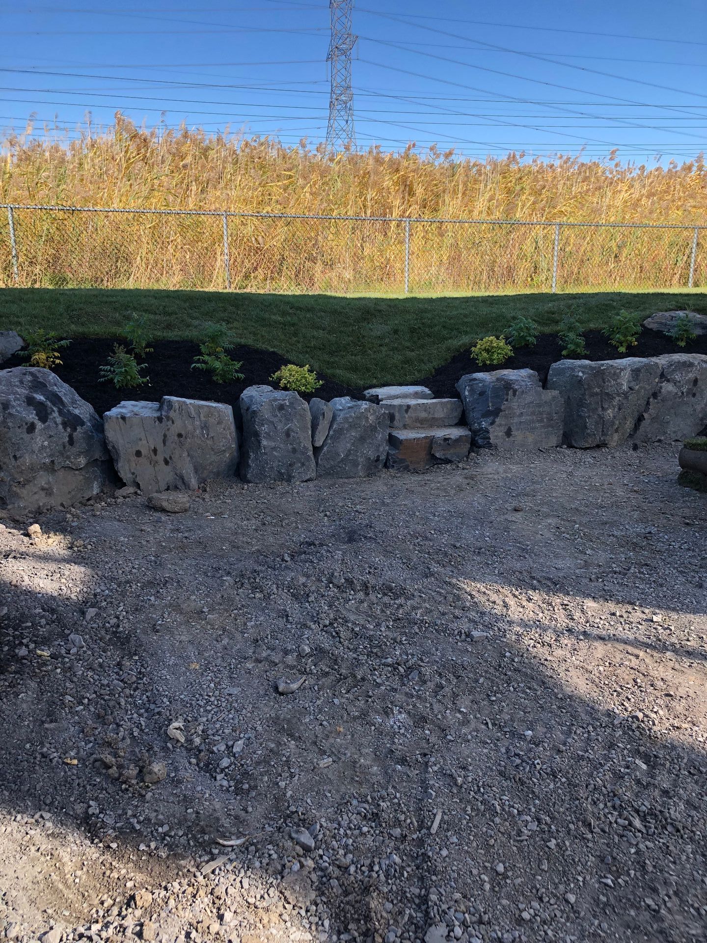 Un mur de pierre avec un foyer au milieu et un champ en arrière-plan.