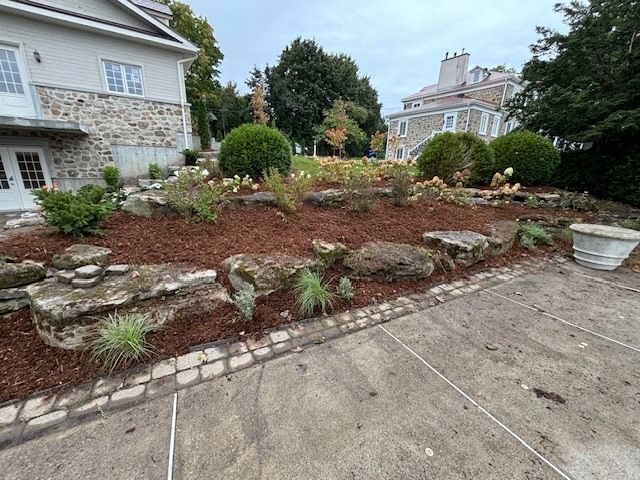 Il y a un grand jardin de rocaille devant une maison.