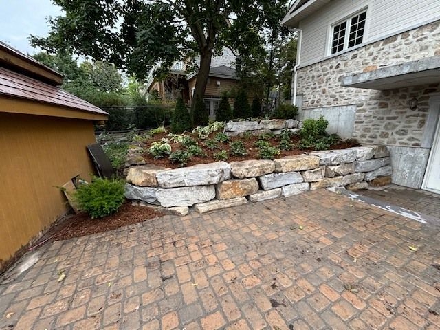 Il y a un mur de pierre dans l'arrière-cour d'une maison.