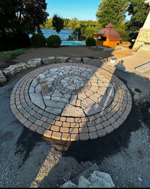 Un patio circulaire en pierre avec un belvédère en arrière-plan