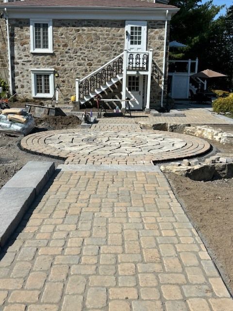 Une maison en pierre avec une allée circulaire devant elle