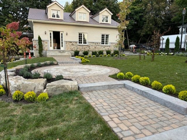 Une maison avec une allée en briques qui y mène