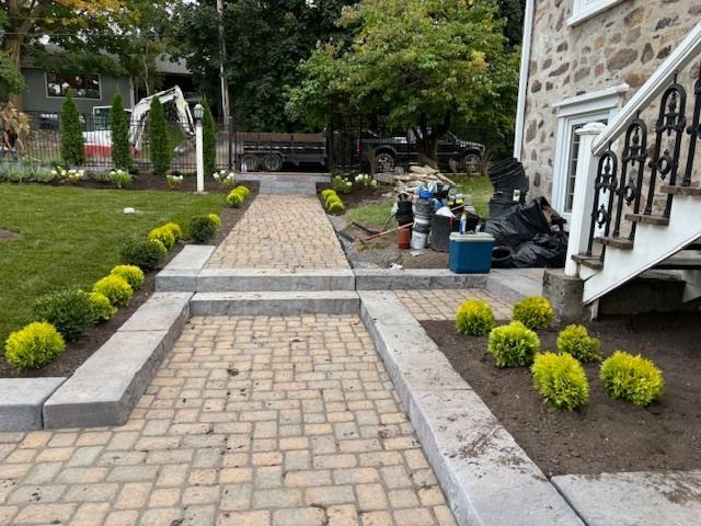 Une passerelle en briques est en cours de construction devant une maison.