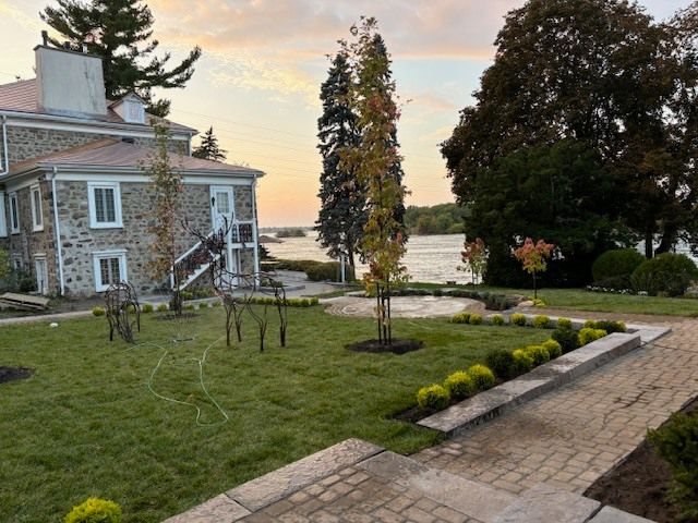 Une grande maison en pierre est située à côté d'un grand plan d'eau.