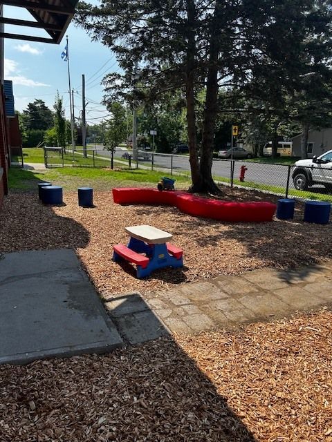 Une aire de pique-nique avec des bancs rouges et une table bleue