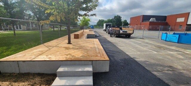 Un camion est garé sur le bord de la route à côté d'un banc en bois.