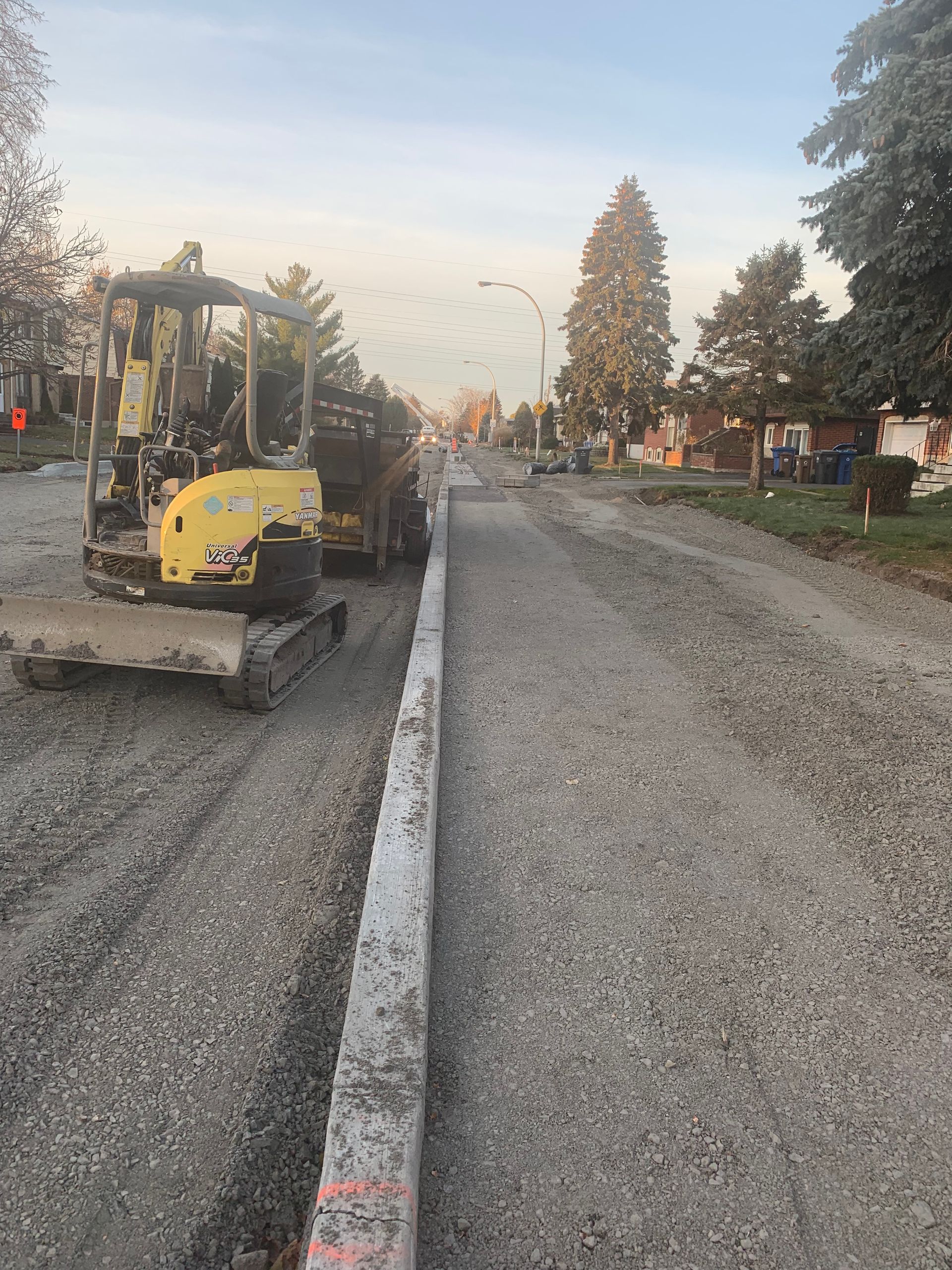 Un bulldozer jaune roule sur une route de gravier.