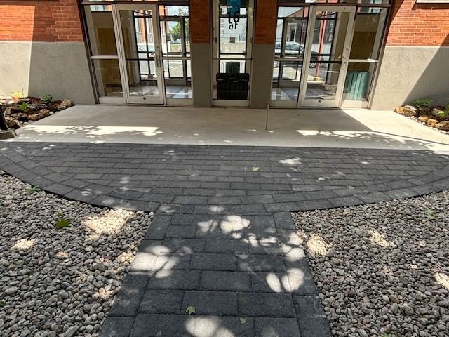 Une allée en briques menant à l'entrée d'un bâtiment.