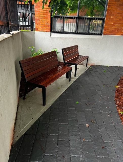 Deux bancs en bois sont assis l'un à côté de l'autre sur un trottoir