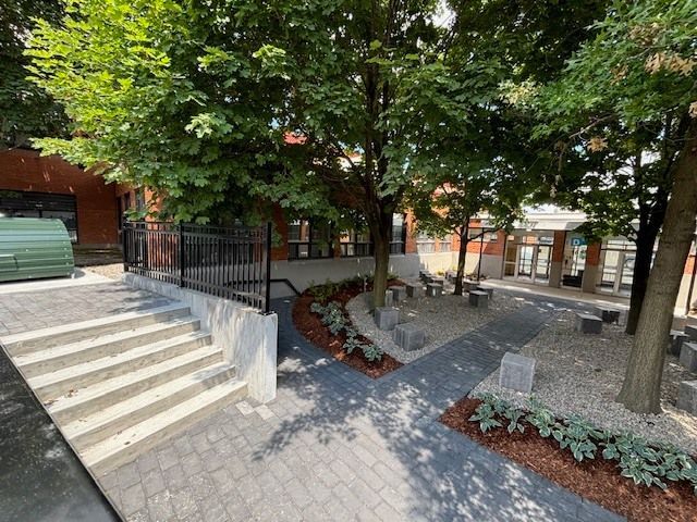 Un escalier menant à un bâtiment avec des arbres devant lui.