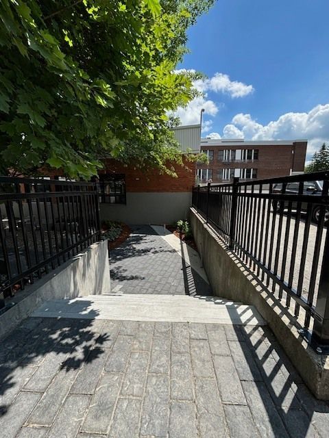 Un escalier menant à un bâtiment avec une clôture en arrière-plan