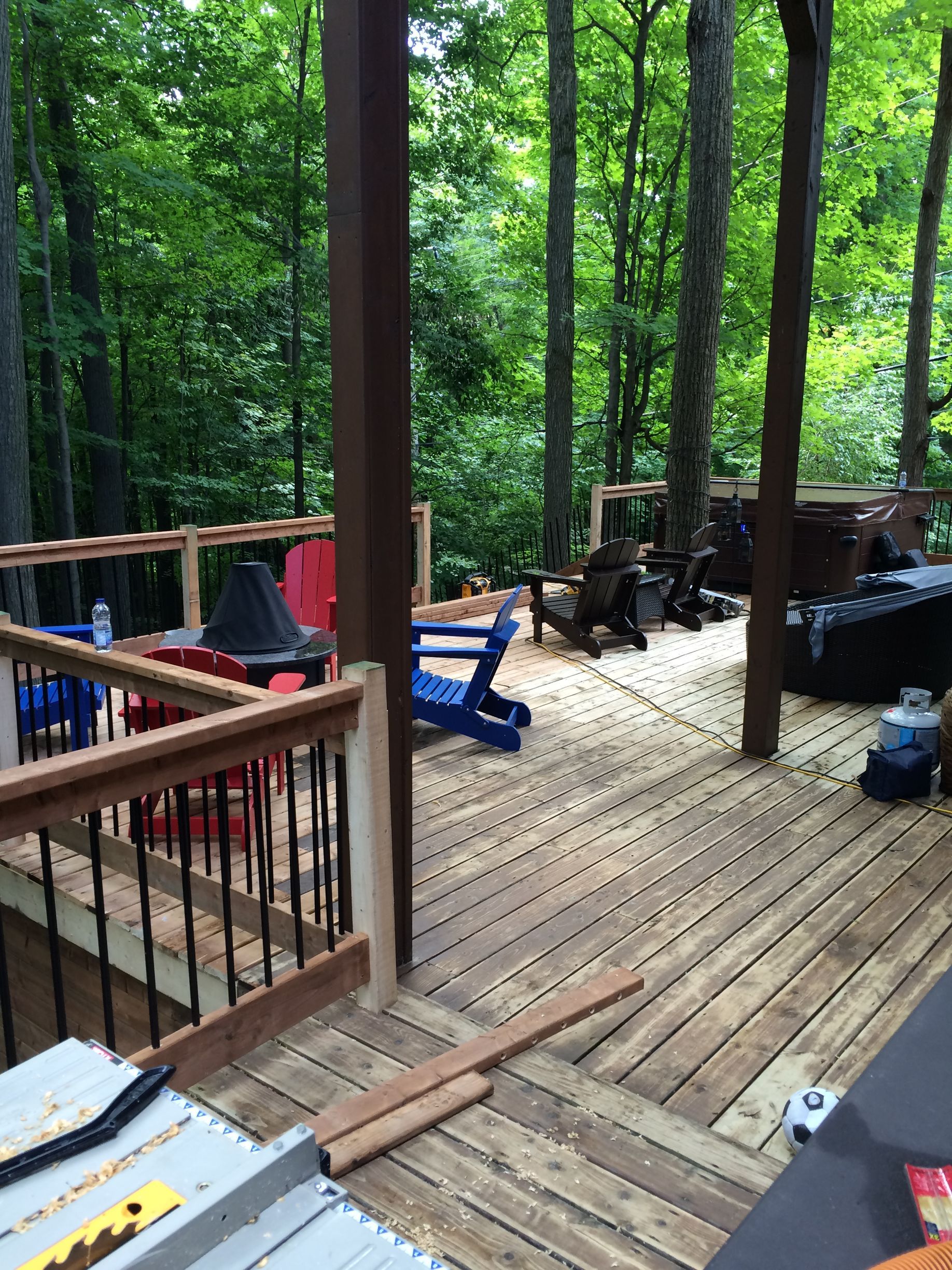 Une terrasse en bois avec des chaises et une table dans les bois