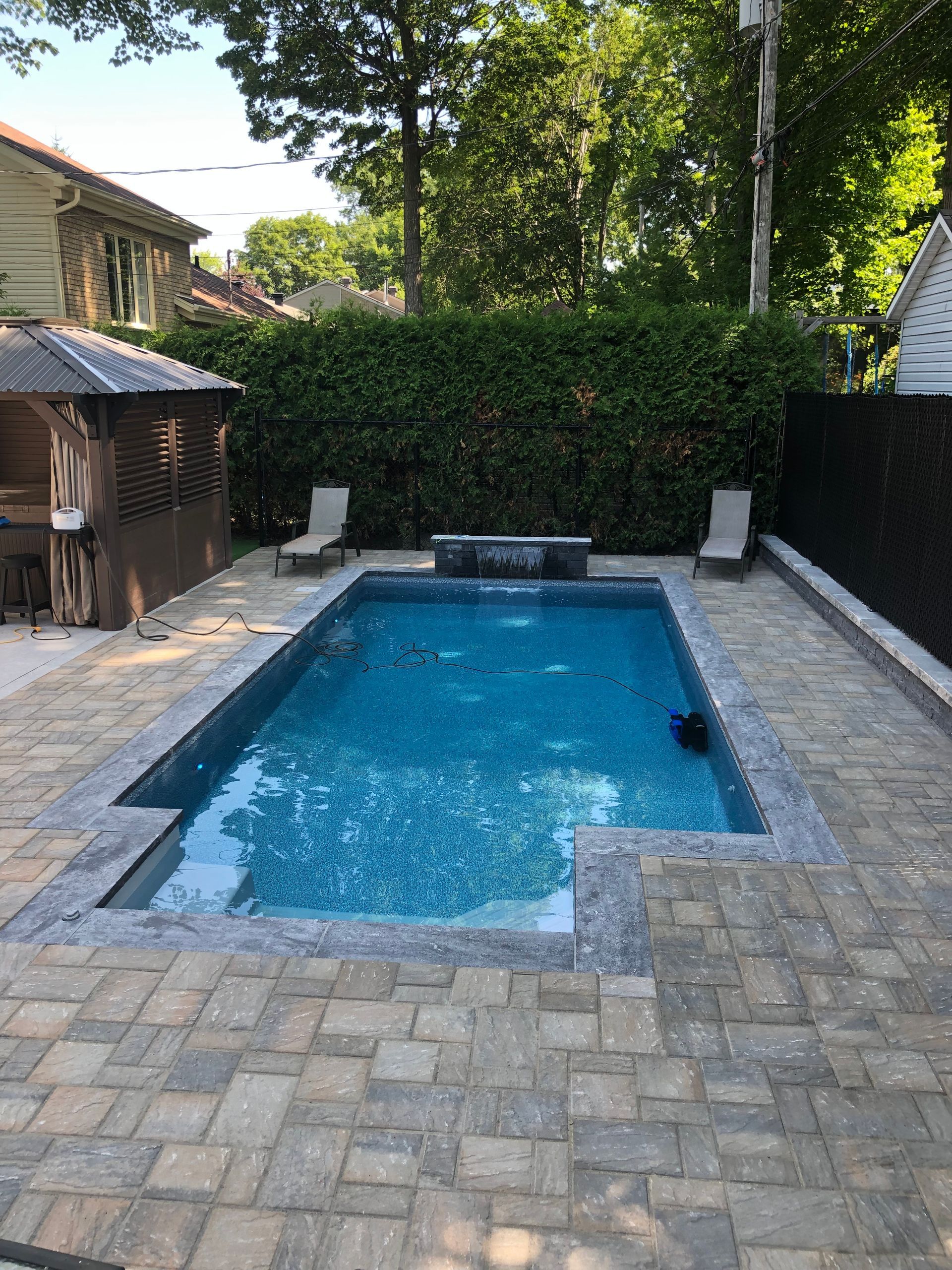 Il y a une grande piscine dans l'arrière-cour d'une maison.