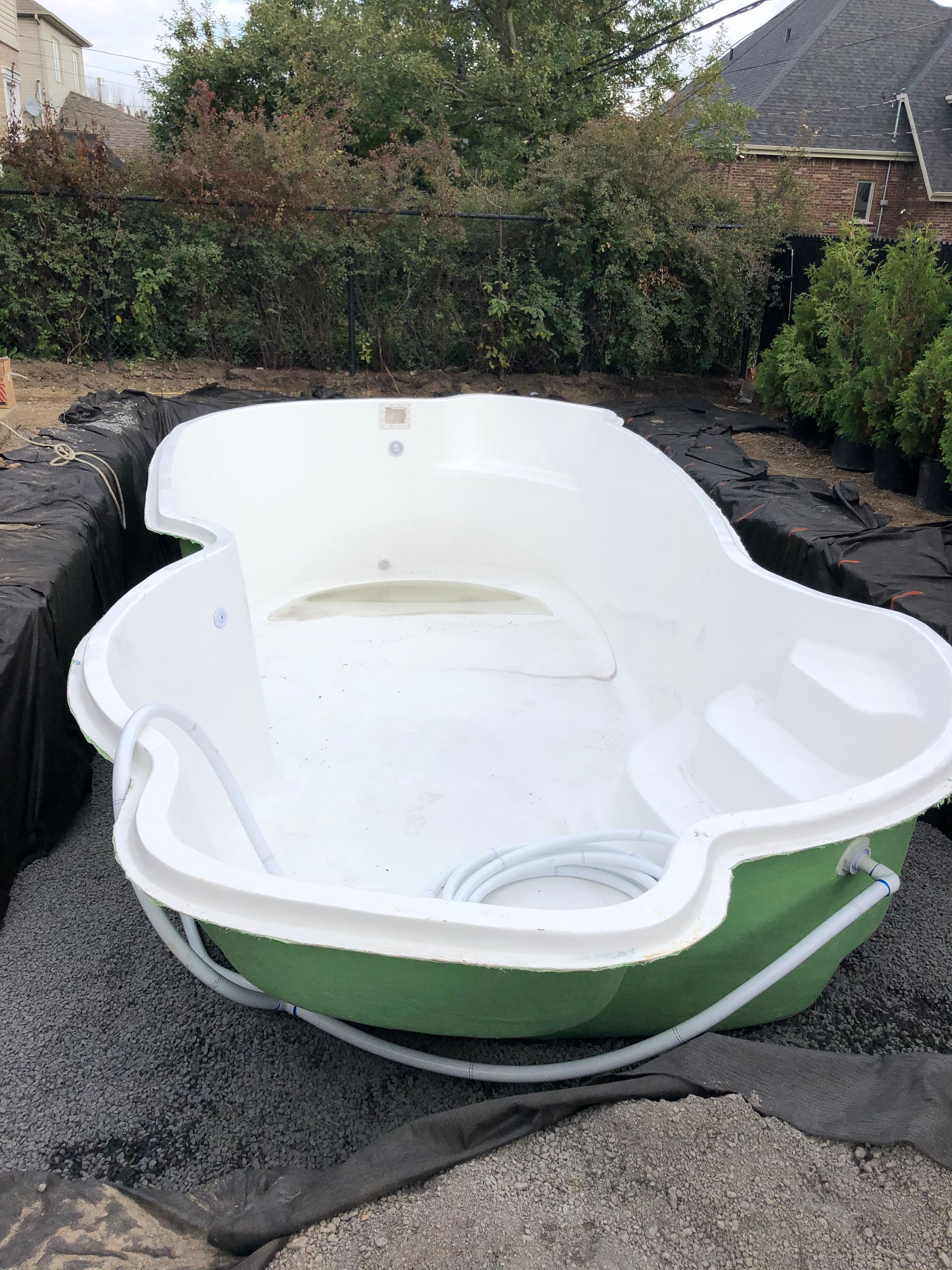 Un bateau vert et blanc est posé sur un tas de gravier.