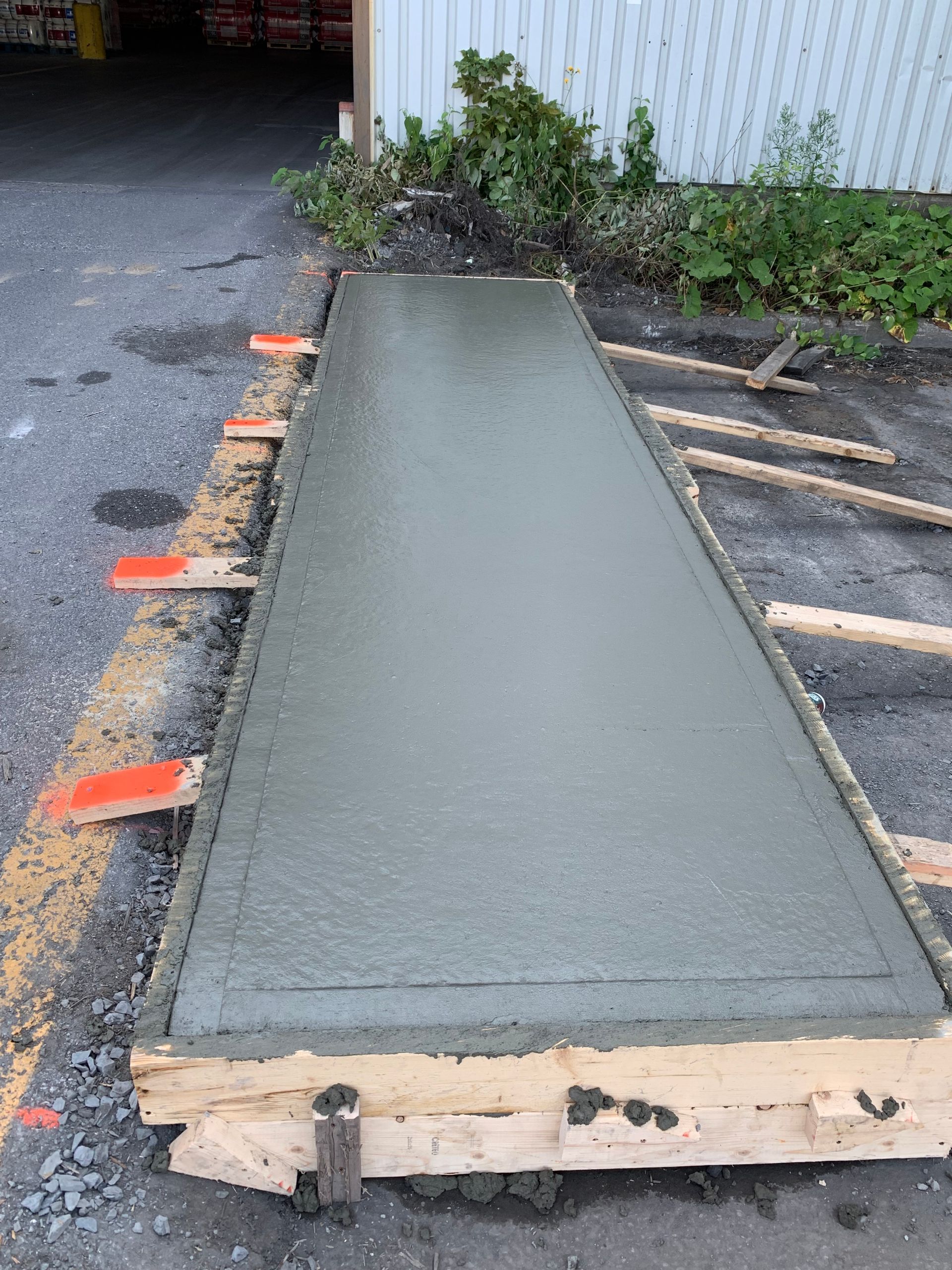 Un long morceau de béton est posé sur le bord de la route.