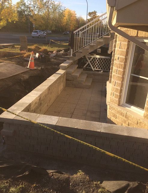 Une maison en briques avec des escaliers en construction sur le côté.