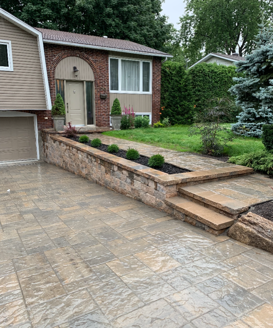 Une maison en brique avec un patio et des escaliers devant.