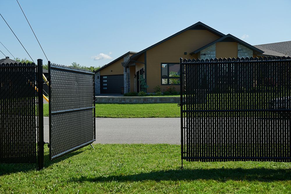 Une maison est derrière une clôture qui est ouverte