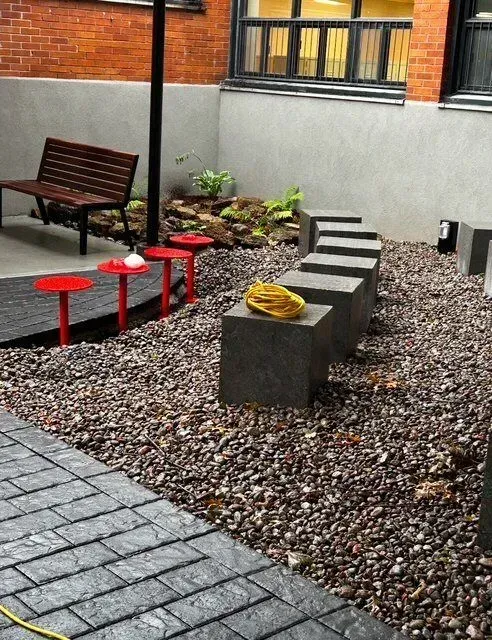 Un casque jaune repose sur un bloc de béton dans une zone de gravier