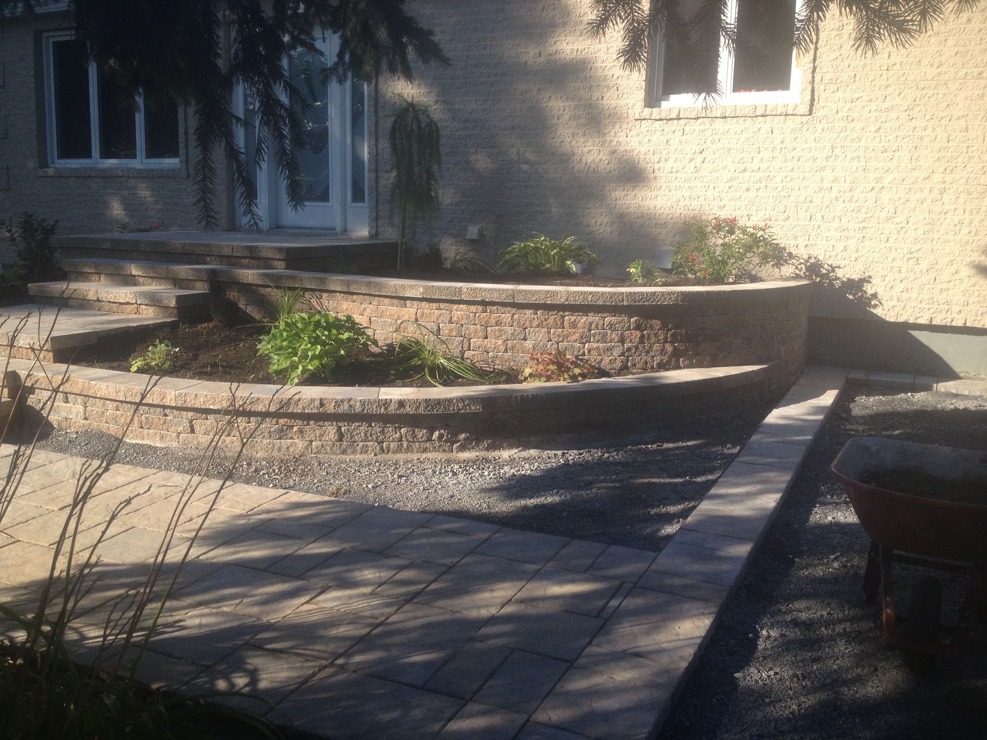 Un mur de briques avec une jardinière devant une maison