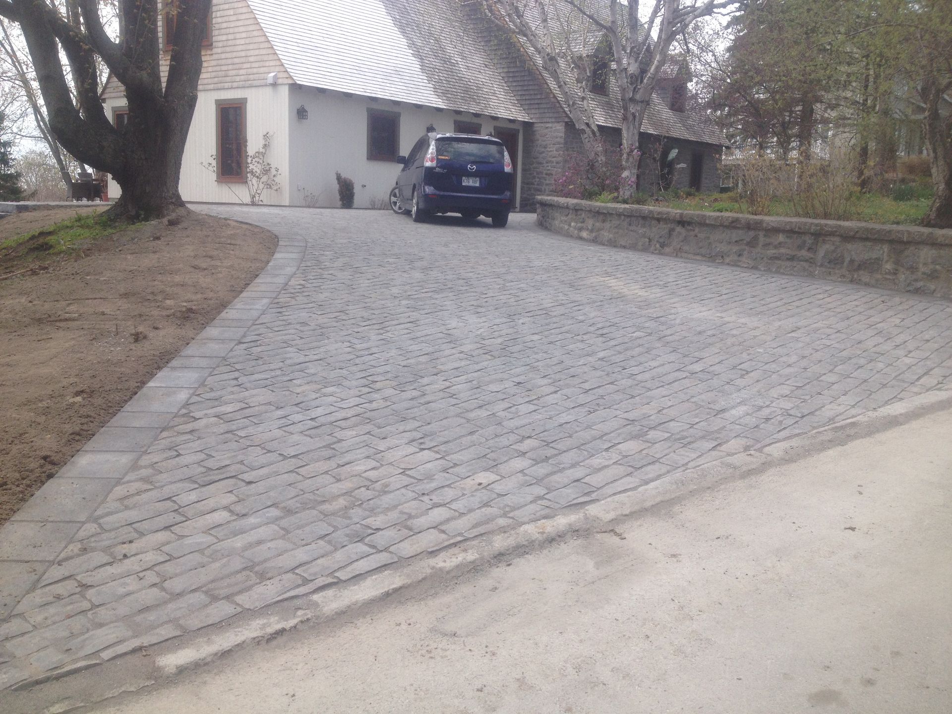 Une voiture est garée dans une allée devant une maison
