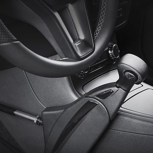 Close-up of a car's steering wheel and hand-operated accelerator and brake lever.