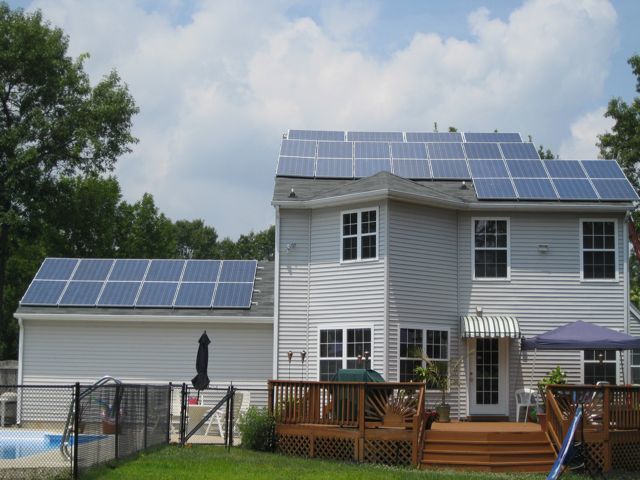 A white house with solar panels on the roof