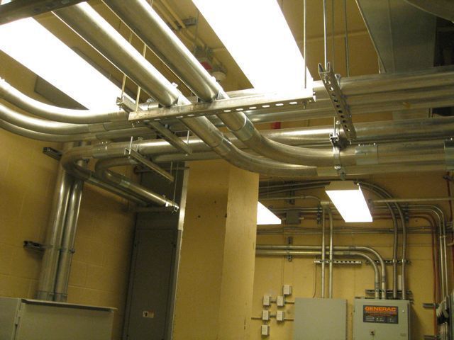 A room with a lot of pipes hanging from the ceiling