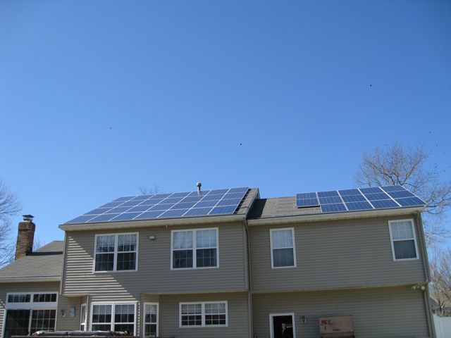 A house with a lot of windows and solar panels on the roof