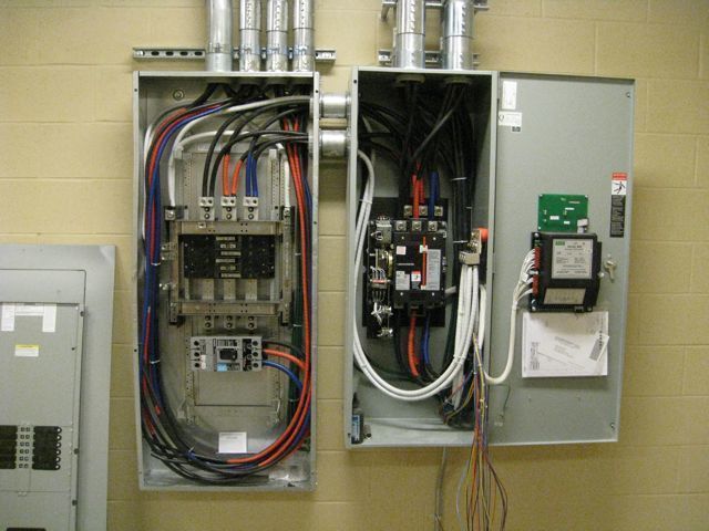 Two electrical boxes are connected to each other on a wall