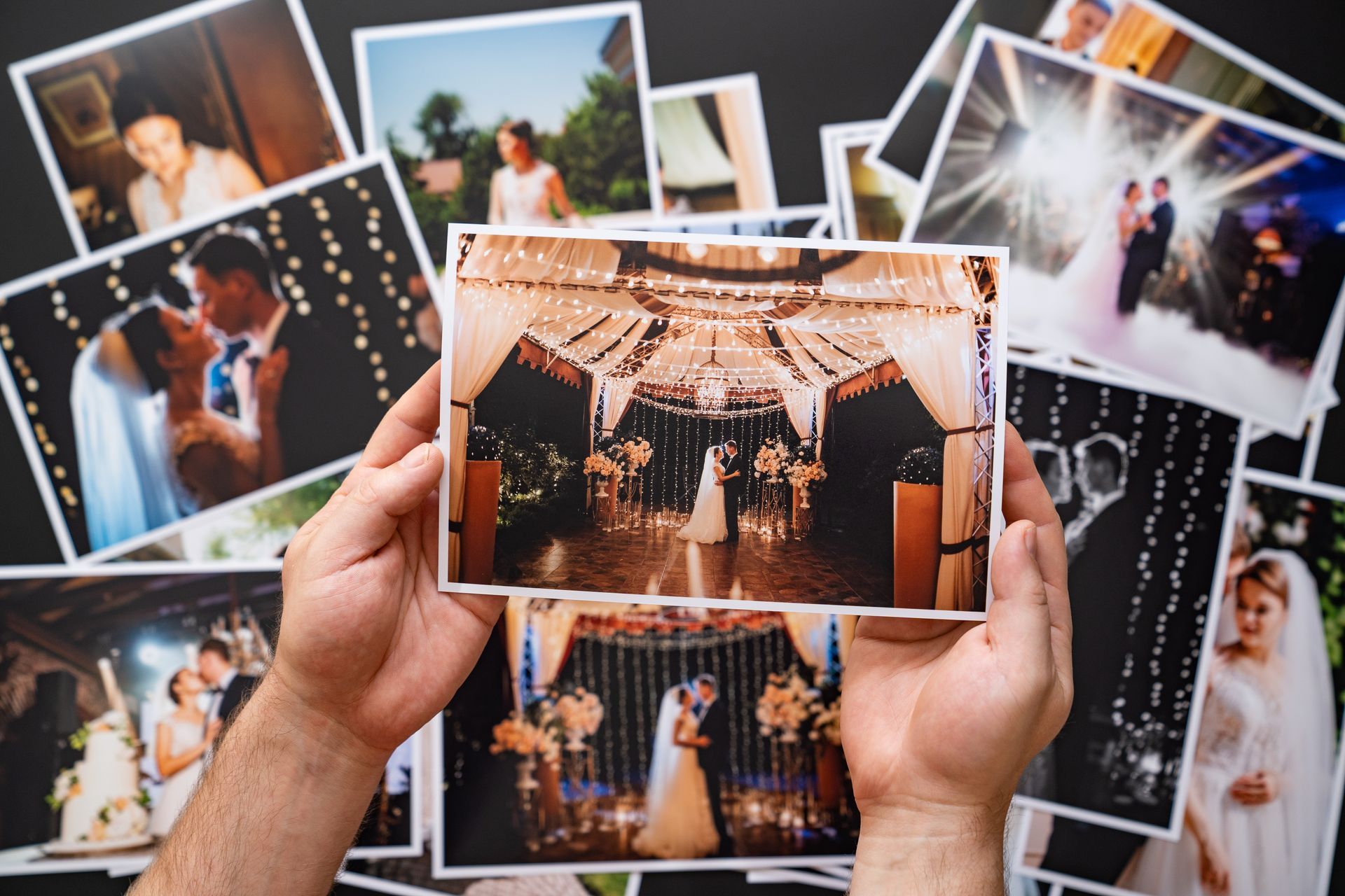 A person is holding a picture of a wedding in their hands.