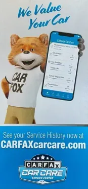 A fox mascot is holding a cell phone in his hand - Select Automotive