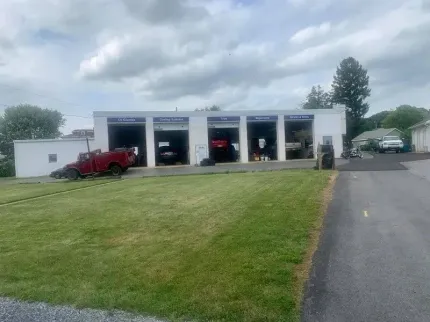 A red truck is parked in front of a tire shop.