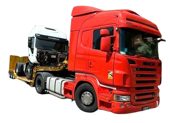 Un camion rosso trasporta un camion bianco su un rimorchio