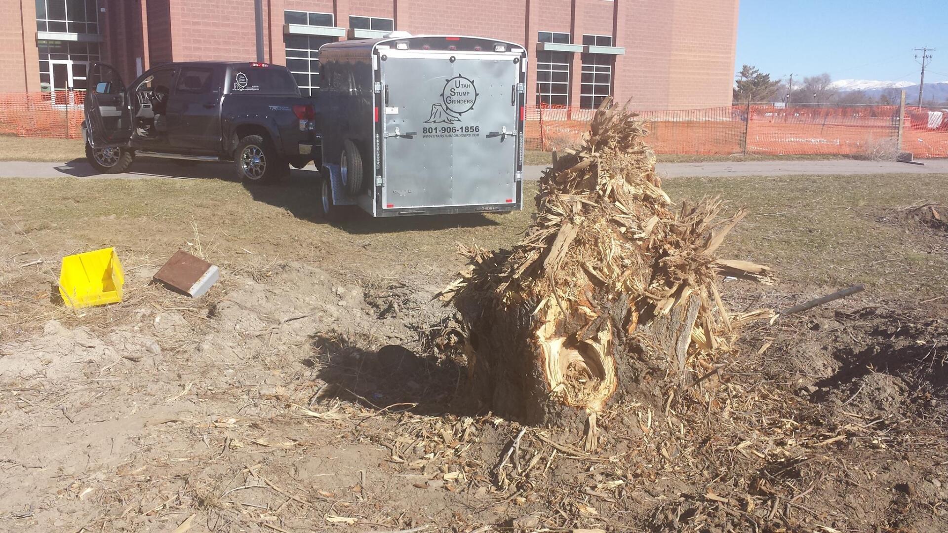 A truck and trailer are parked in front of a brick building