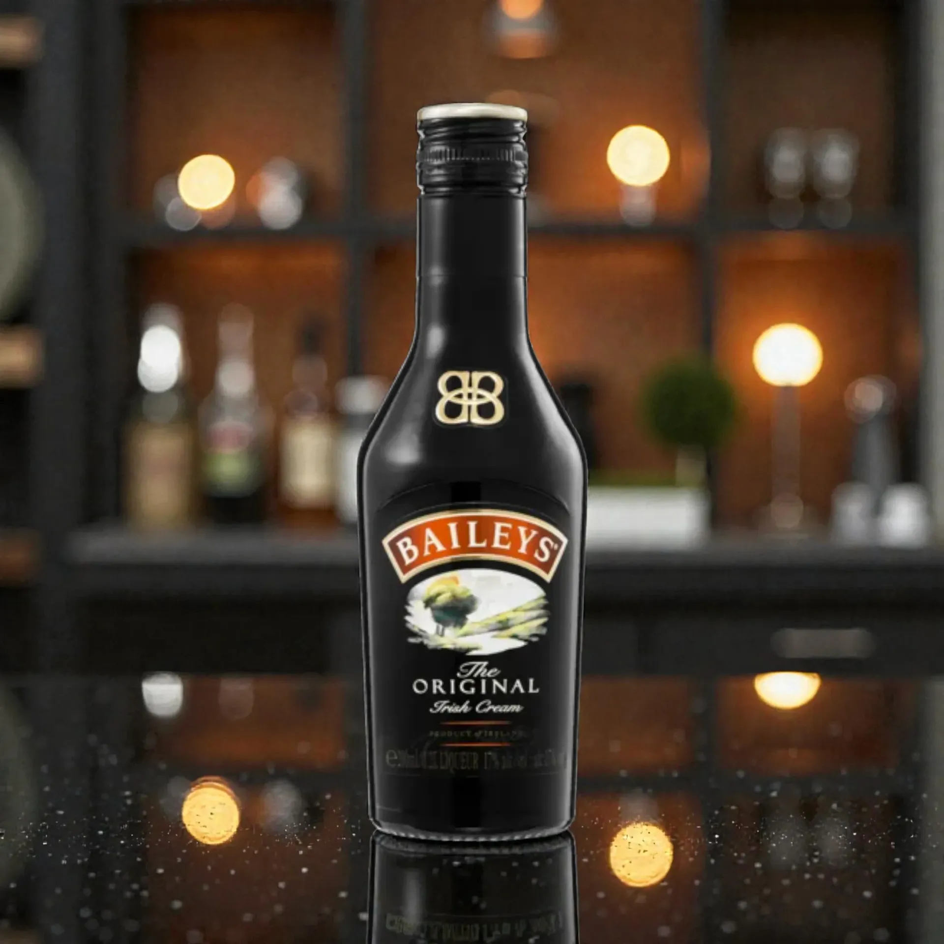 Bottle of Baileys Irish Cream liqueur on a reflective surface, with a blurry bar background.