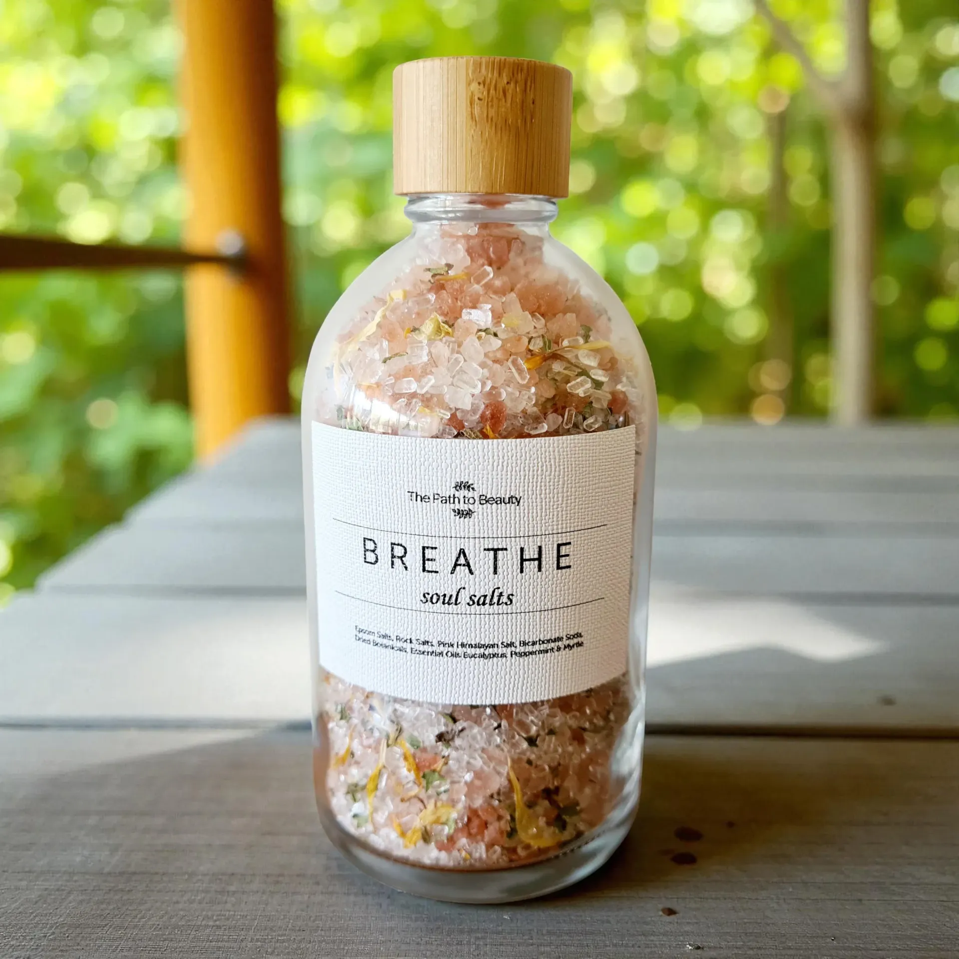 A clear glass jar of bath salts labeled 