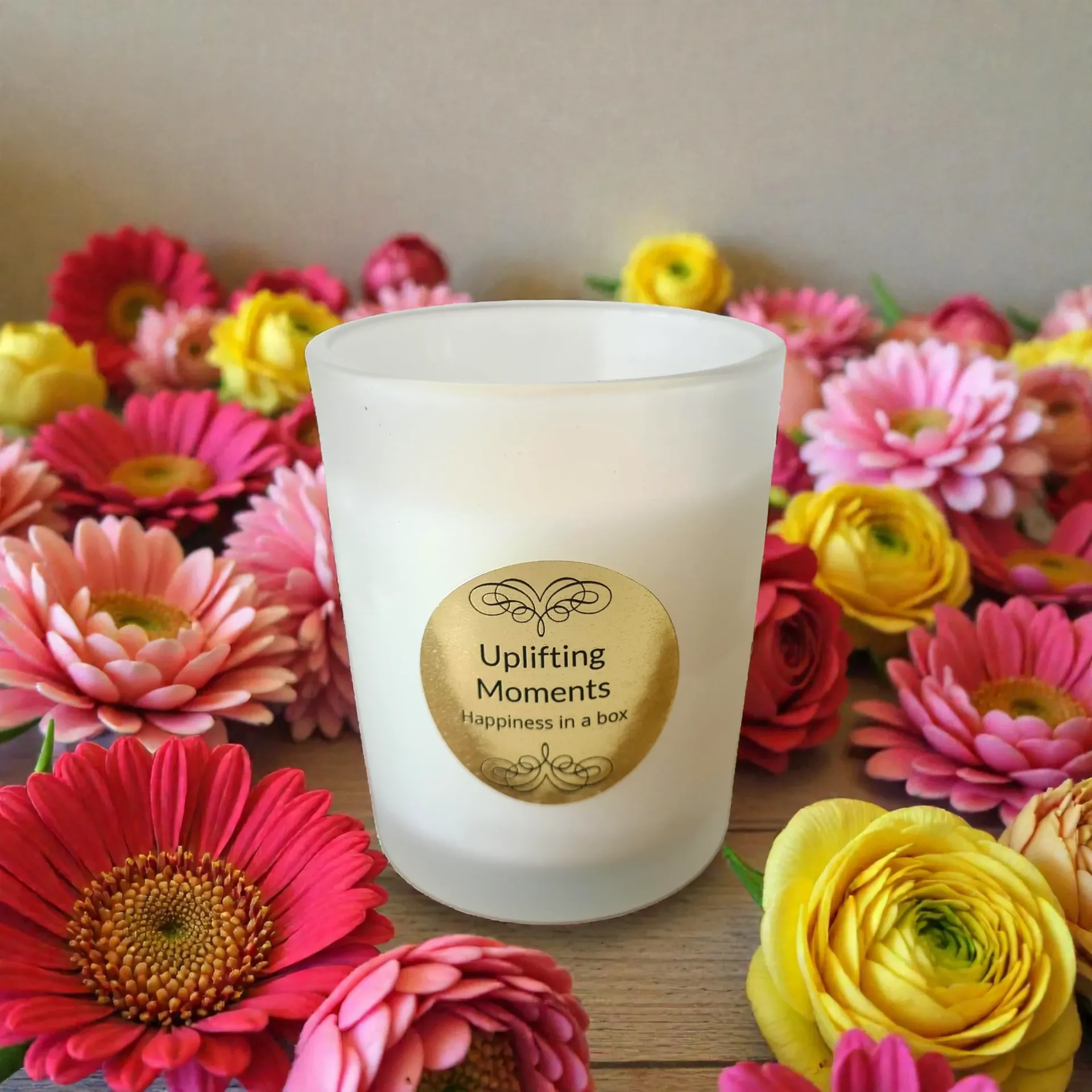 A white candle with a gold label reading 