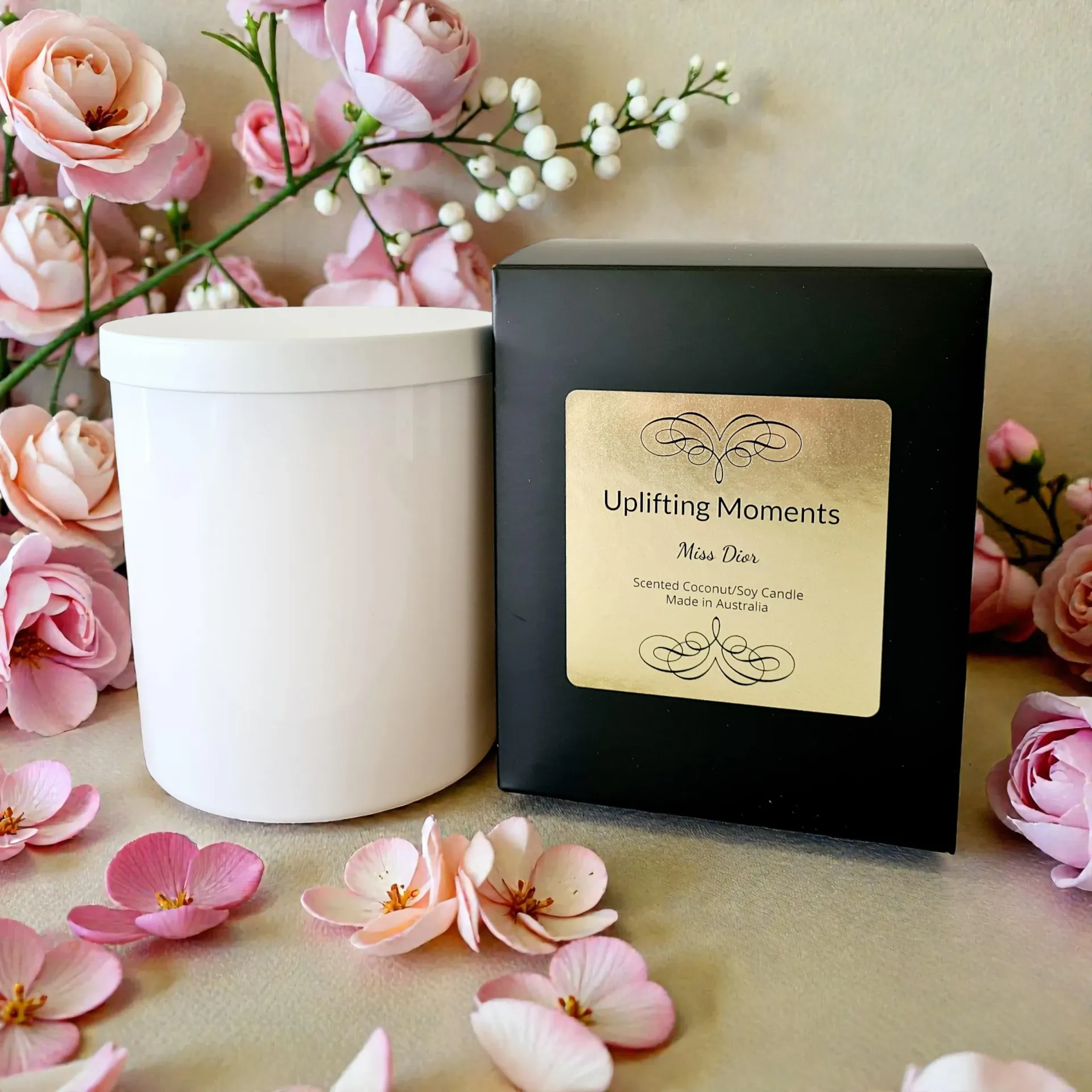 White candle with lid, surrounded by pink and cream roses.
