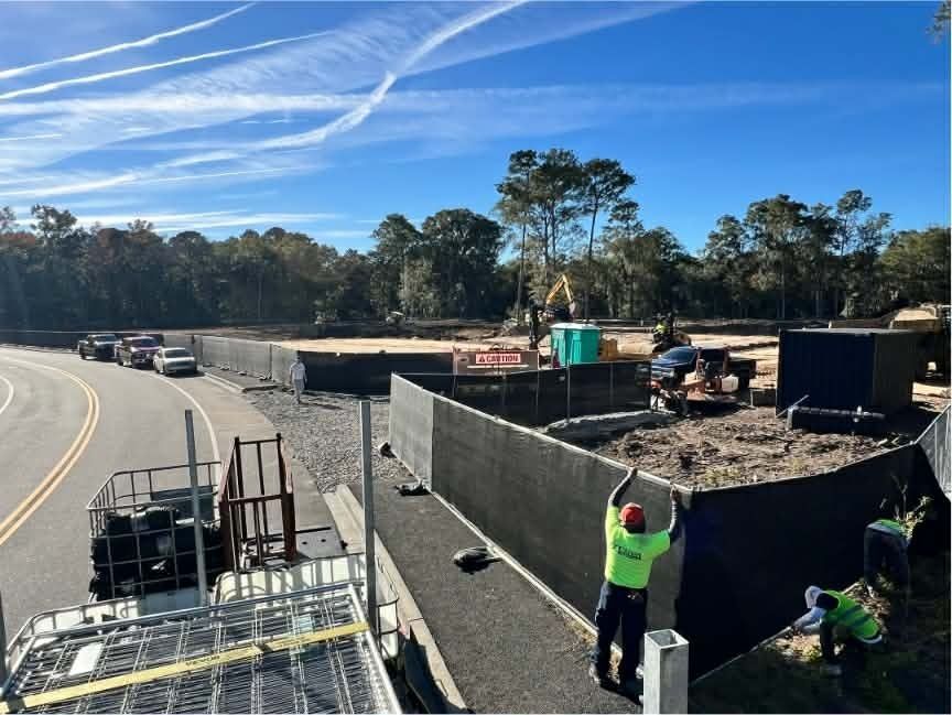 Black temporary fence with a green 