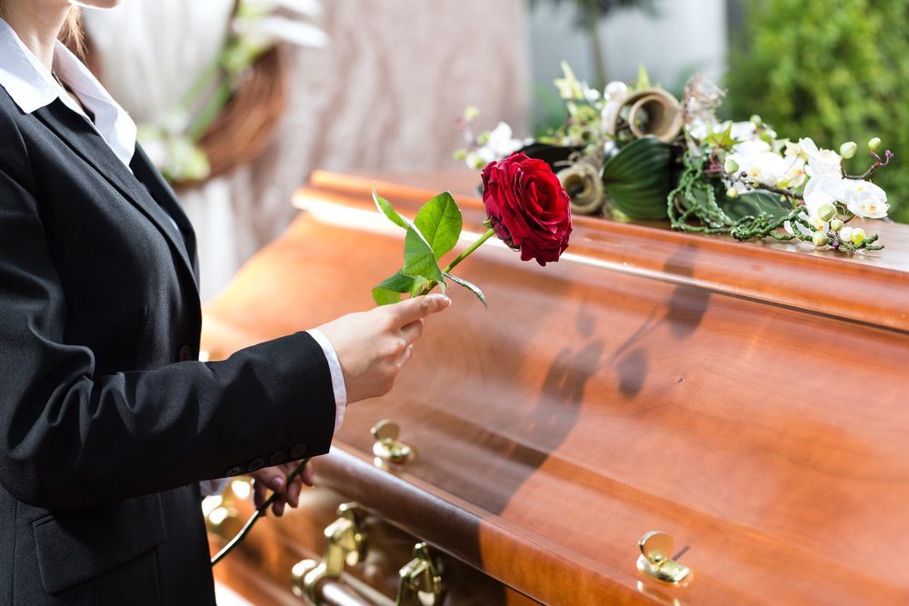 Morning Woman On Funeral With Red Rose Standing At Coffin — Create A Personalised Funeral On The Central Coast, NSW