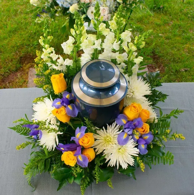 An Urn Surrounded by Colourful Flowers — Personalised Cremation Services in The Entrance, NSW